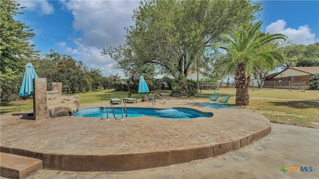 view of swimming pool with a yard and a patio area