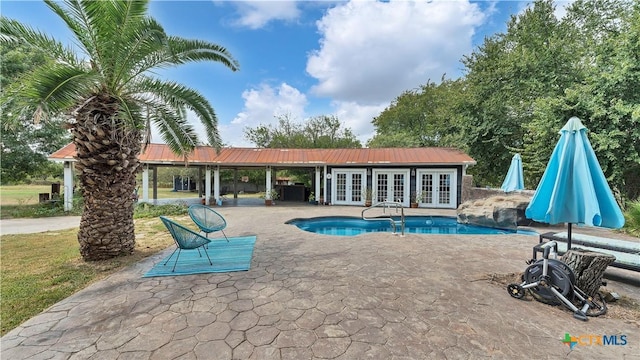 view of pool featuring a patio, an outdoor structure, and french doors