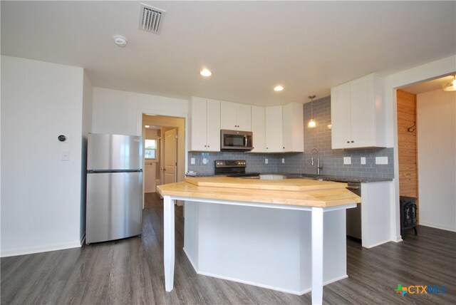 kitchen with tasteful backsplash, a kitchen island, dark hardwood / wood-style flooring, white cabinetry, and stainless steel appliances