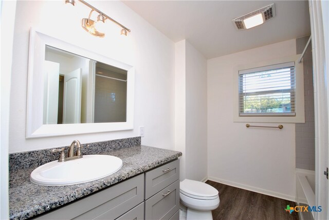 bathroom with hardwood / wood-style flooring, vanity, and toilet