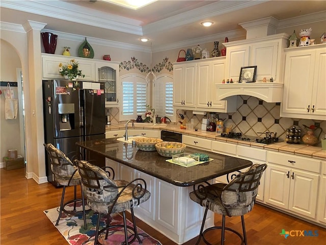 104 Woodcreek Cir, Victoria, TX 77904 - kitchen with black appliances, a kitchen breakfast bar, white cabinets, crown molding, and recessed lighting