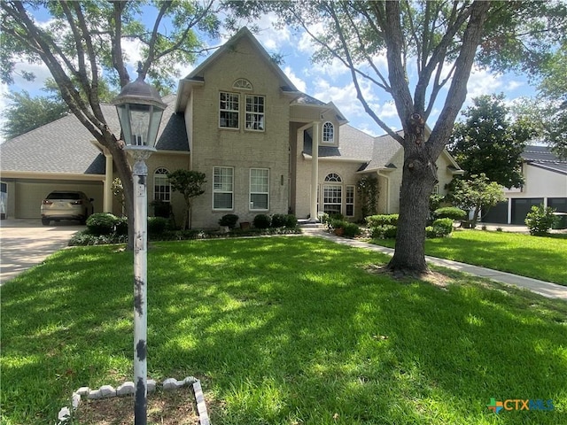 104 Woodcreek Cir, Victoria, TX 77904 - view of front of home with an attached garage, concrete driveway, a front yard, and a shingled roof