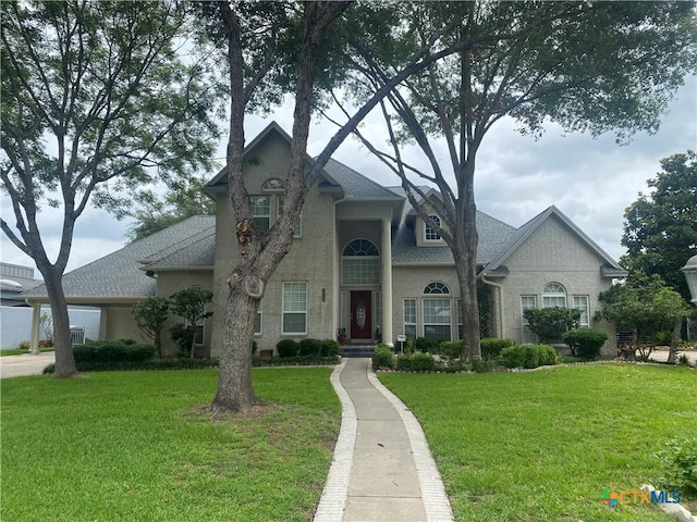 104 Woodcreek Cir, Victoria, TX 77904 - view of front of property featuring a front yard, roof with shingles, and brick siding