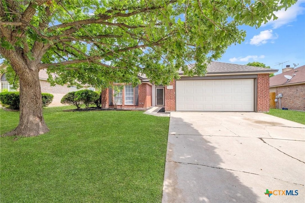 1808 Stratford Dr, Temple, TX 76502 - view of front of property with brick siding, an attached garage, driveway, and a front lawn
