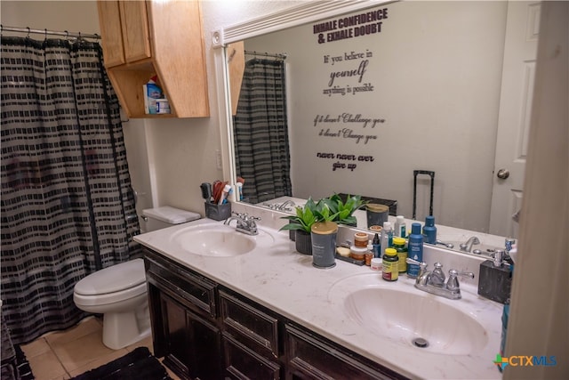 bathroom with toilet, vanity, and tile patterned floors