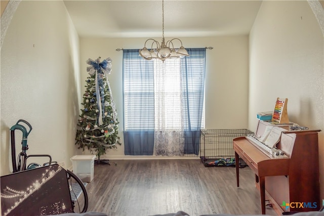 misc room with hardwood / wood-style floors and an inviting chandelier