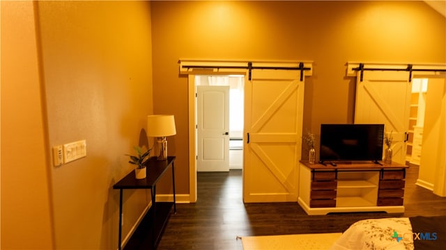 bedroom featuring dark wood-type flooring and a barn door