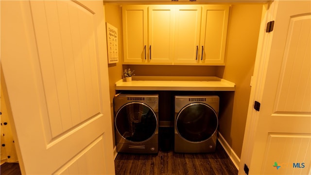 washroom featuring cabinets, dark hardwood / wood-style flooring, and washing machine and clothes dryer