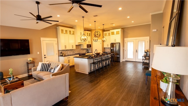 living room with dark hardwood / wood-style floors, sink, ceiling fan, crown molding, and french doors