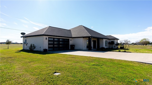 prairie-style home with a garage and a front lawn