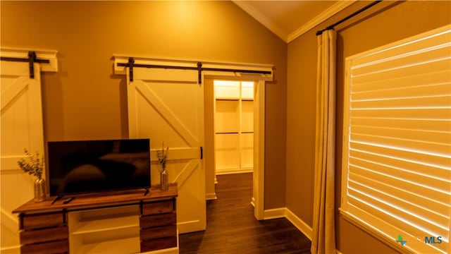 interior space featuring dark hardwood / wood-style floors, a barn door, and vaulted ceiling