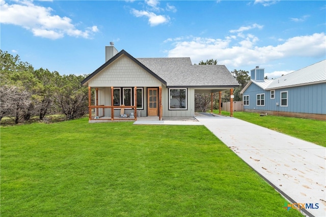 rear view of property with a yard, a carport, and a porch