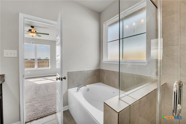 bathroom featuring tile patterned flooring, a bathtub, and ceiling fan