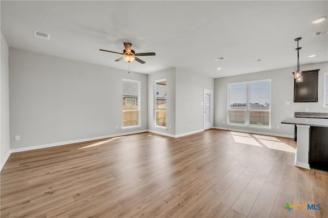 unfurnished living room with ceiling fan and light hardwood / wood-style flooring