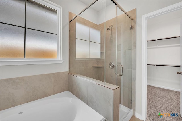 bathroom featuring shower with separate bathtub