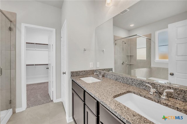 bathroom featuring tile patterned flooring, vanity, and an enclosed shower