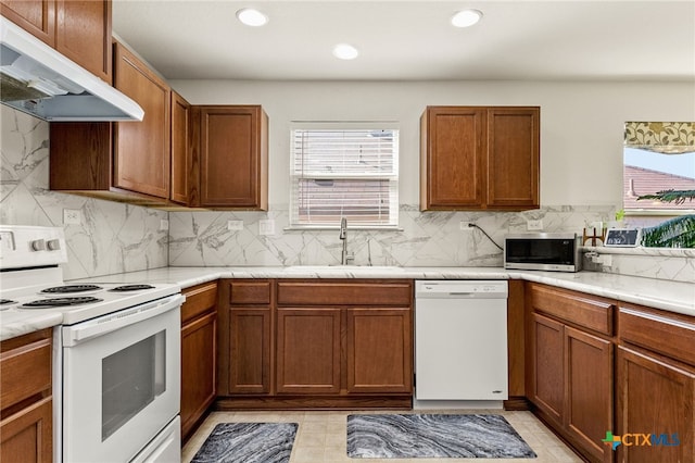 3946 Legend Pond, New Braunfels, TX 78130 - kitchen with white appliances, under cabinet range hood, a sink, decorative backsplash, and light countertops