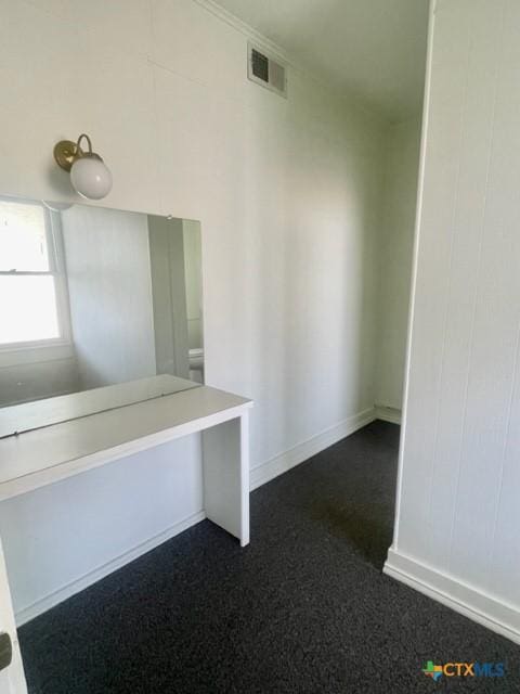 interior space featuring dark carpet, baseboards, and visible vents