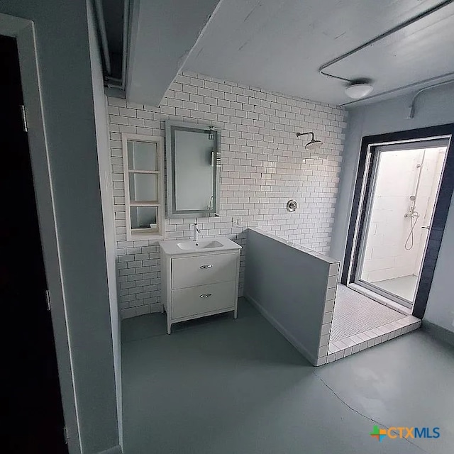 bathroom featuring concrete floors, walk in shower, and vanity