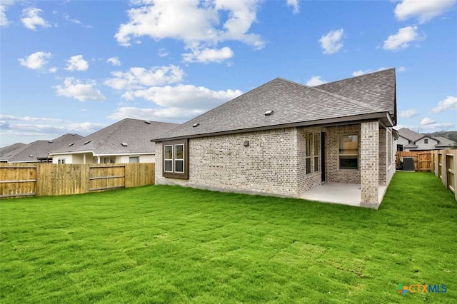 rear view of house featuring a patio area and a yard