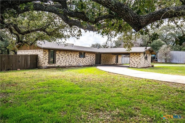 ranch-style home featuring a front lawn and a carport