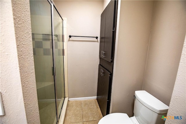 bathroom with an enclosed shower, tile patterned flooring, and toilet