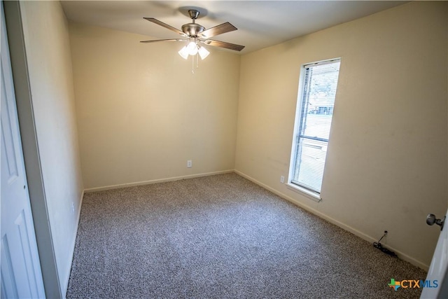 carpeted spare room featuring ceiling fan