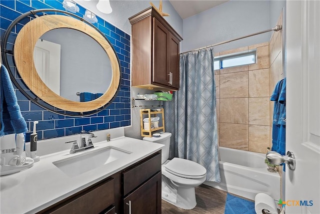 full bathroom with shower / tub combo with curtain, tile walls, hardwood / wood-style flooring, vanity, and toilet