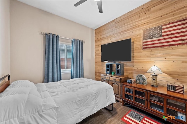 bedroom featuring dark wood-type flooring, wooden walls, and ceiling fan