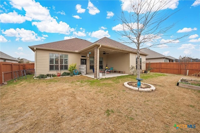 rear view of house featuring a yard, ceiling fan, and a patio area