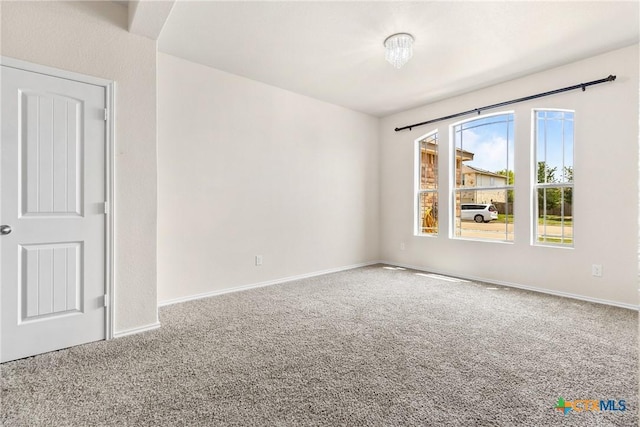 carpeted spare room with baseboards