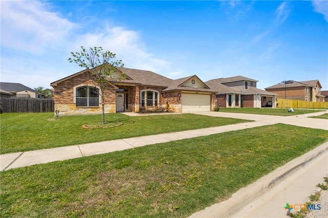 view of front facade with fence, driveway, a front yard, and a garage