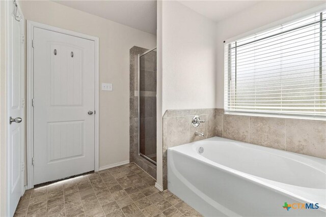 full bath featuring a bath and a shower stall