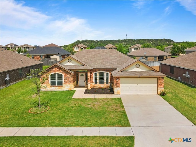 view of front of home with driveway, an attached garage, a front yard, brick siding, and a residential view