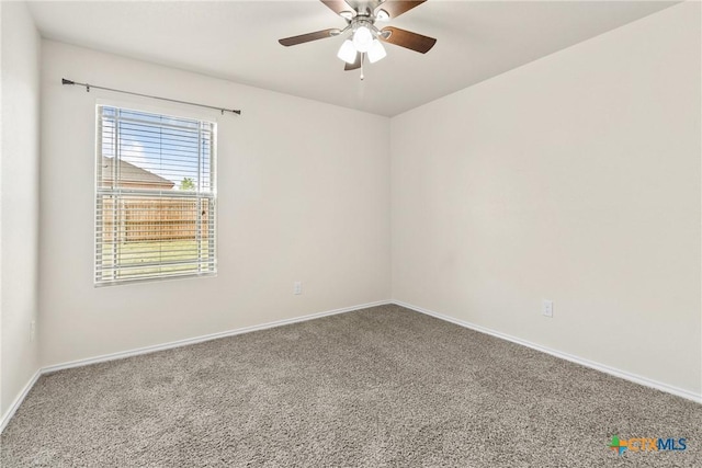 carpeted spare room featuring ceiling fan and baseboards
