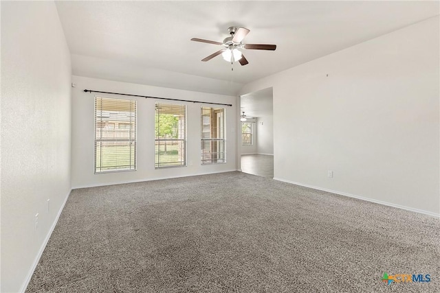 carpeted spare room with baseboards and a ceiling fan