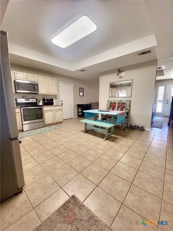 kitchen with light tile patterned floors, appliances with stainless steel finishes, visible vents, and baseboards