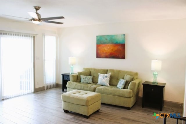 living room with wood-type flooring and ceiling fan