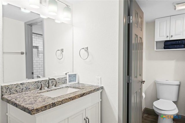 bathroom featuring vanity, hardwood / wood-style floors, and toilet