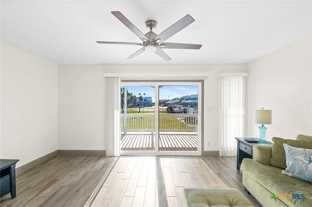 living room featuring ceiling fan and light hardwood / wood-style flooring