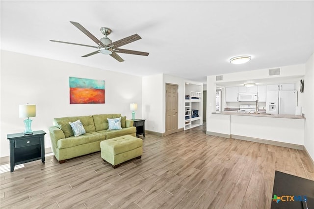 living room with ceiling fan and light hardwood / wood-style flooring