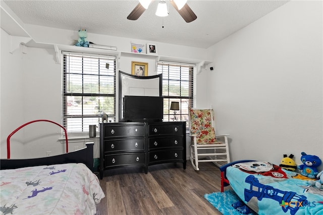 bedroom with dark wood-type flooring, a textured ceiling, and ceiling fan