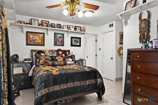 bedroom featuring a closet, light tile patterned floors, and ceiling fan