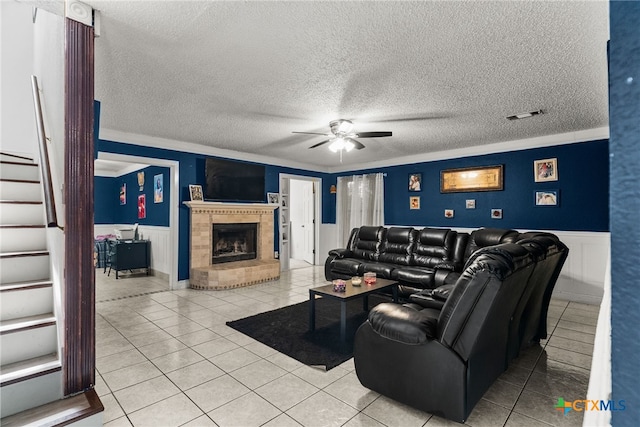 tiled living room featuring ornamental molding, a textured ceiling, and ceiling fan