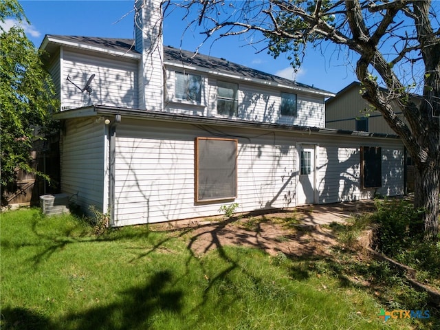 back of house featuring a lawn