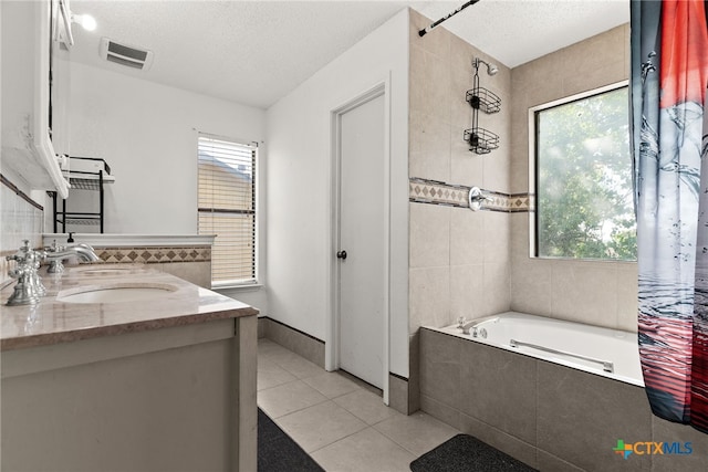 517 Margaret Lee St, Copperas Cove, TX 76522 - bathroom featuring a relaxing tiled tub, tile patterned flooring, double vanity, a textured ceiling, and a tile shower