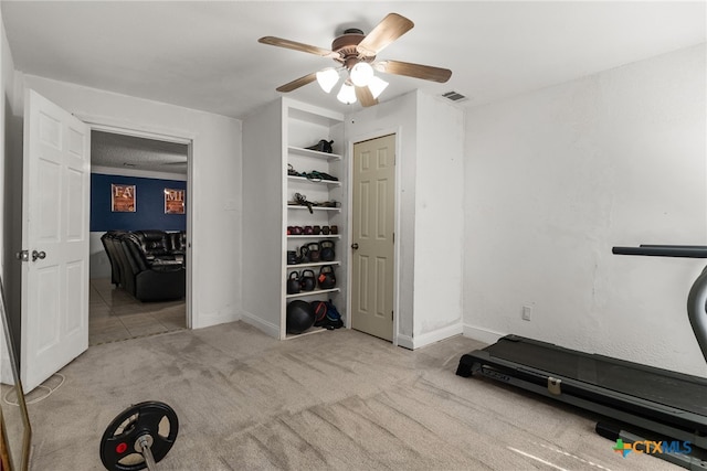 workout area featuring ceiling fan and light carpet