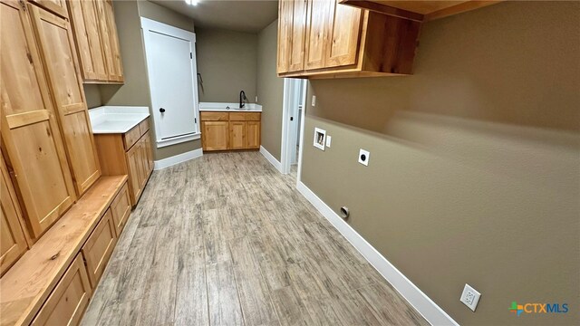 laundry area with cabinets, light hardwood / wood-style floors, sink, washer hookup, and hookup for an electric dryer