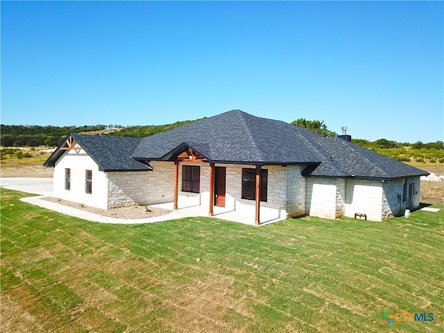 back of house with a lawn and a patio area