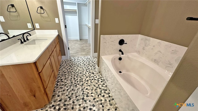 bathroom with a bath, tile patterned flooring, and vanity